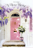 A sunlit West Norwood doorstep becomes a quiet celebration of a fresh chapter, with a pale pink front door standing as the gentle focal point. The door, painted in a soft pastel tone, seems to glow in the mild afternoon light that drifts along the street, its colour harmonising beautifully with the cascades of lavender wisteria spilling overhead. Each trailing cluster of blossom hangs gracefully, forming an almost storybook arch that frames the entrance and softens the lines of the whitewashed wall and pale shutter beside it. At the threshold, a vintage-style grey bucket holds a generous bouquet of white and cream roses, artfully arranged with muted greenery. The blooms look full and velvety, some rose heads more open than others, creating a sense of life and movement as petals curl outward. Dusty-toned foliage adds subtle contrast and a slightly rustic feel, as though gathered from a garden near Norwood Park. A soft pink ribbon encircles the base of the bucket, tied in a relaxed but elegant bow that mirrors the tone of the door and ties the entire composition together. The light is gentle, casting faint, painterly shadows from the wisteria vines across the doorstep, making the setting feel sheltered and calm, like a pause between unpacking boxes and greeting new neighbours. Crafted with the sensitivity of an experienced local florist, this arrangement seems perfect for a housewarming in West Norwood-a floral gesture that brings comfort, good fortune, and a sense of warm welcome to a much-anticipated new home.